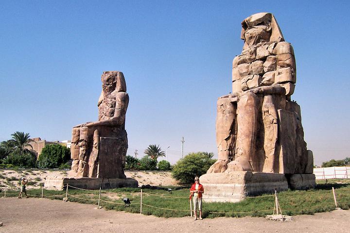 100_9924.JPG - Memnonovy kolosy zpodobňující Amenhotepa III. Jsou vysoké 16,6 m stojí na podstavci 2,3 m. Jediný pozůstatek zaniklého chrámu.